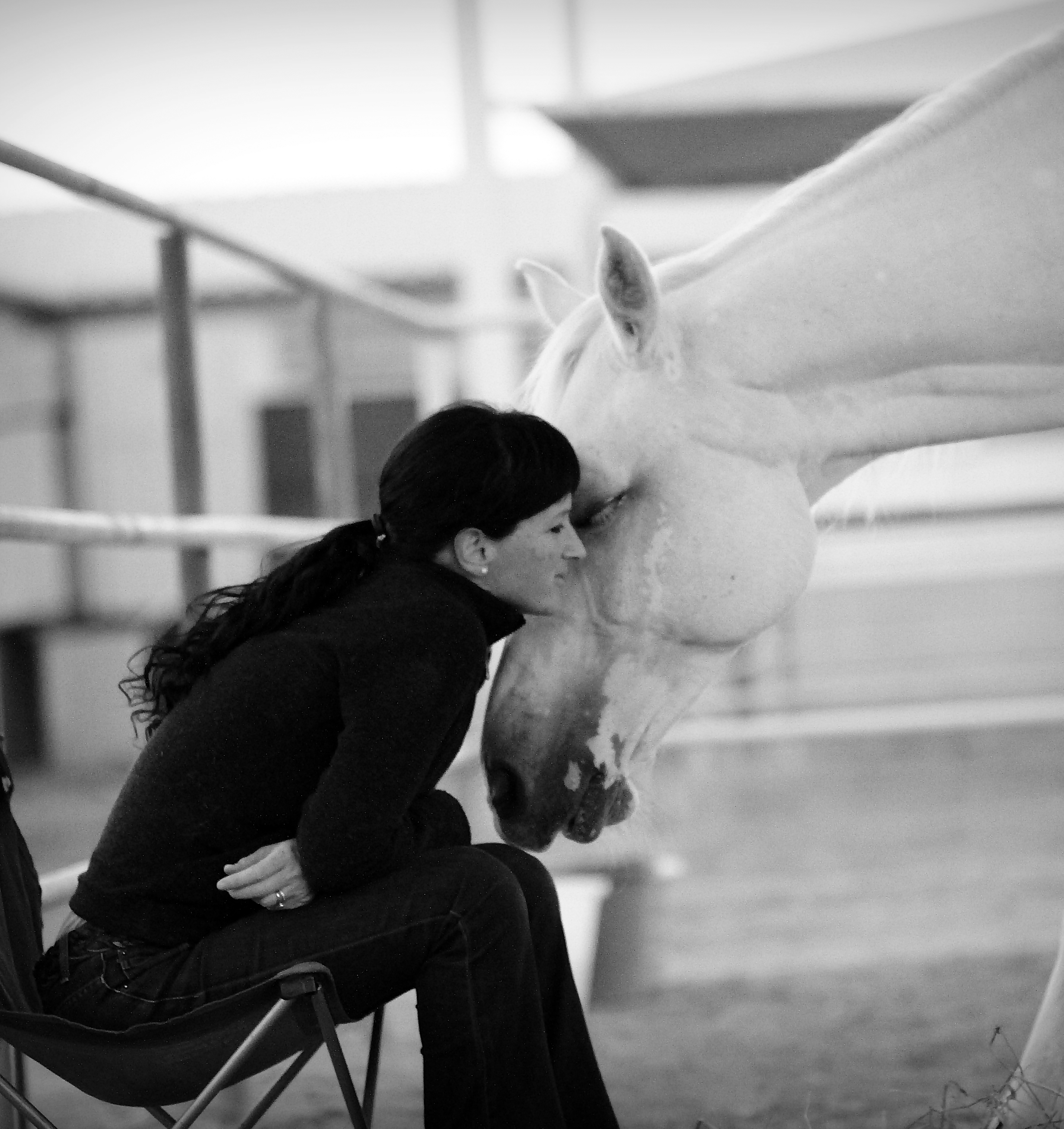 A close, intimate frame: a woman's eye in soft light, pressed against the warm flank of a chestnut horse.