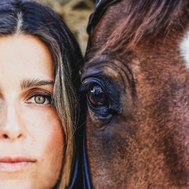 Eye to eye — white horse and a red-haired woman.