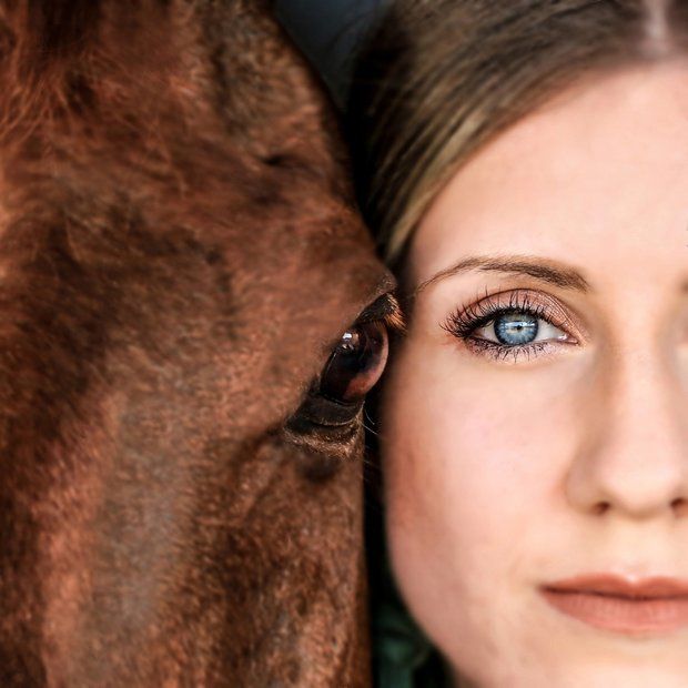 Woman and chestnut horse, eye close-up.